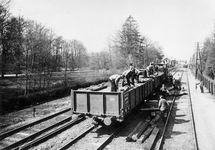 168947 Afbeelding van het lossen van dwarsliggers op de spoorlijn nabij het N.S.-station Driebergen te ...